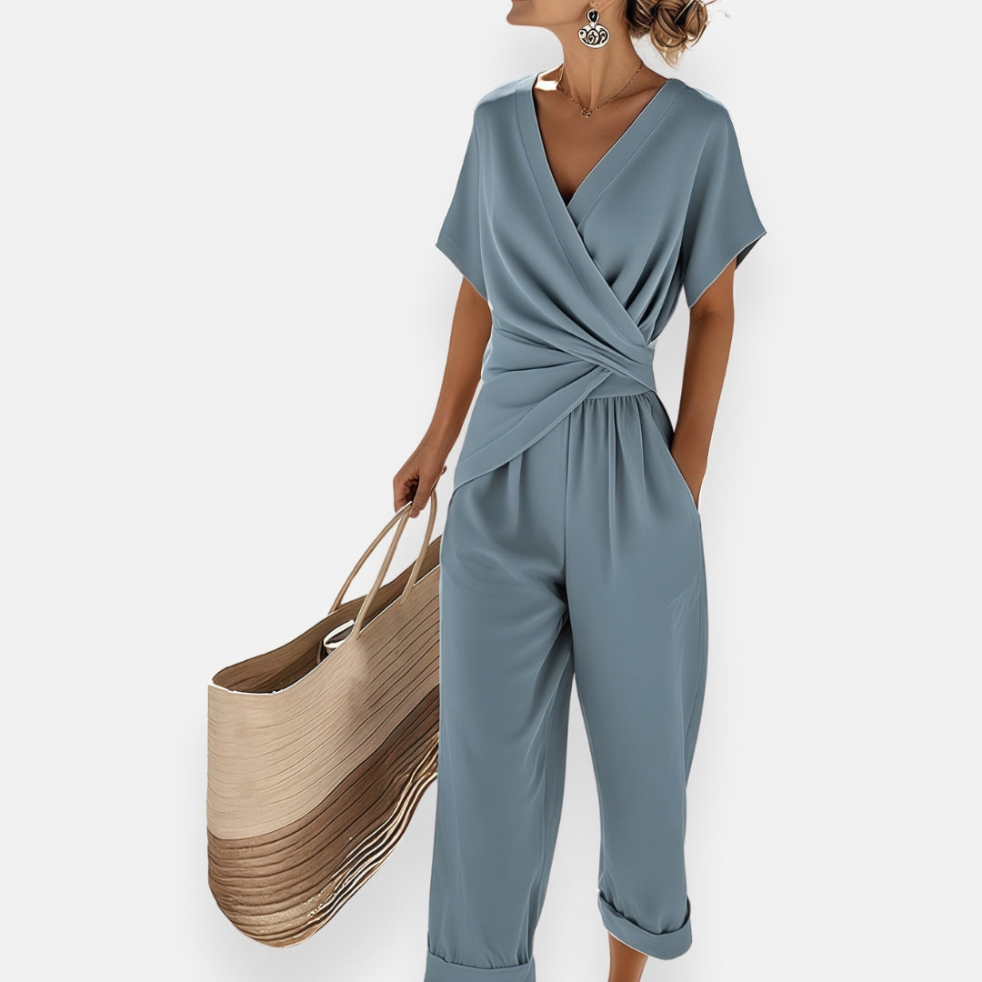 Femme portant une combinaison pantalon beige avec cache-cœur drapé et jambes larges
